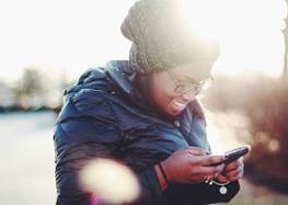 Kvinna som tittar i sin mobiltelefon