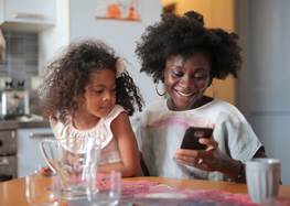 Vuxen och barn som tittar på en smartphone