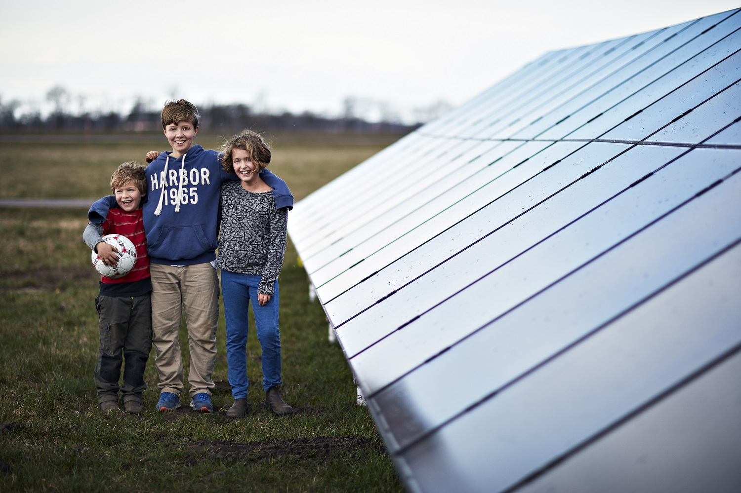 Barn står bredvid en solcellsanläggning
