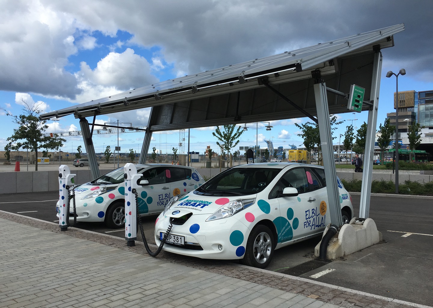 Två elbilar står på laddning