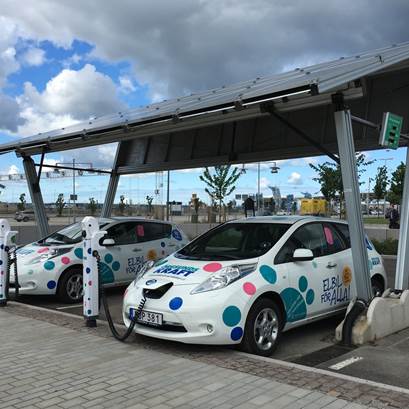 Två elbilar står på laddning