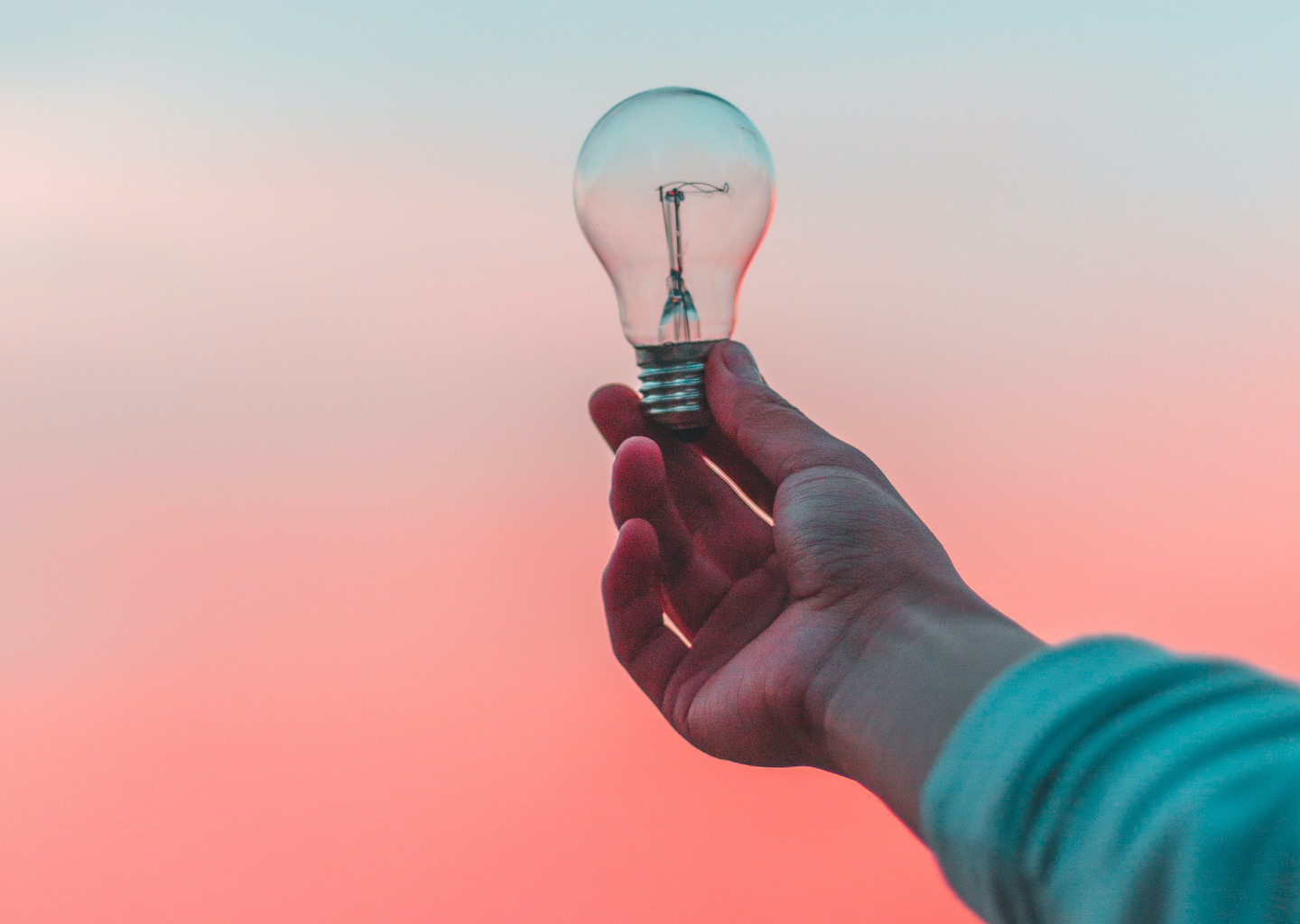 En hand som håller i en glödlampa